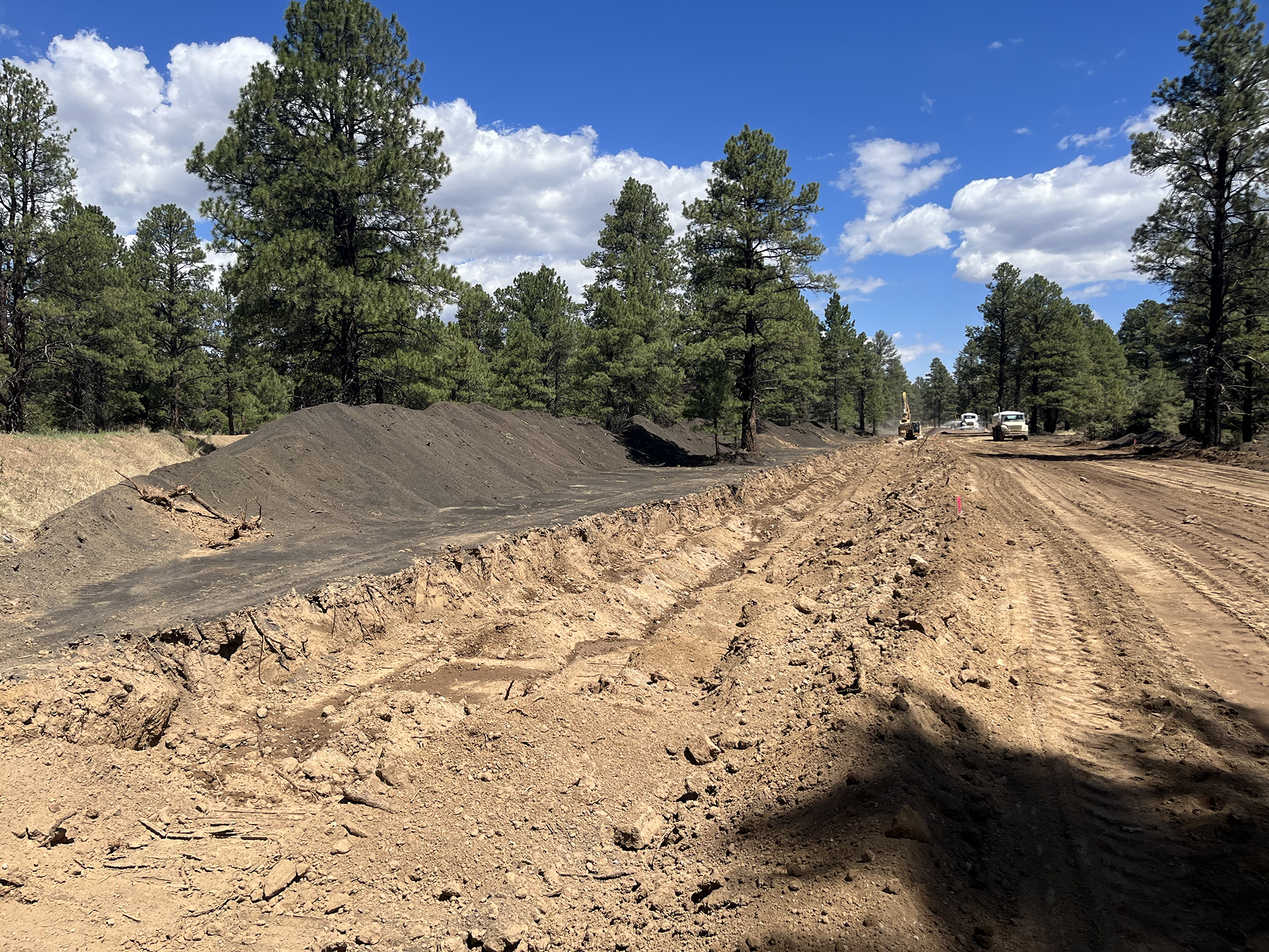 Construction vehicles work to prevent post-wildfire flooding.