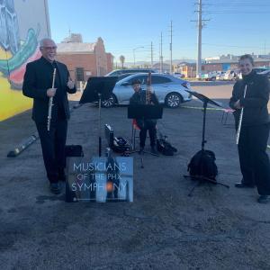 Trio of musicians playing in a parking lot