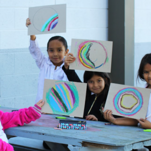 Girls holding up their artwork